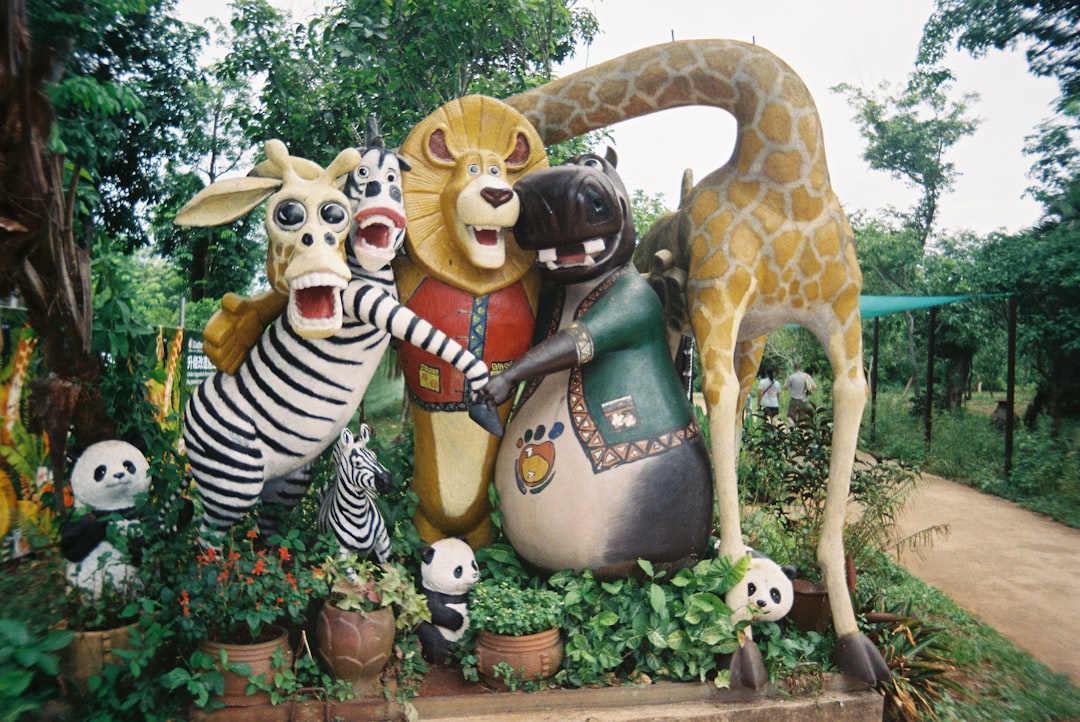 Madagascar characters statues in a lush garden.
